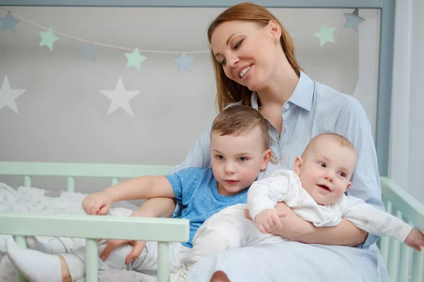 Šťastný střední věku matky se svými dětmi v posteli — Stock fotografie