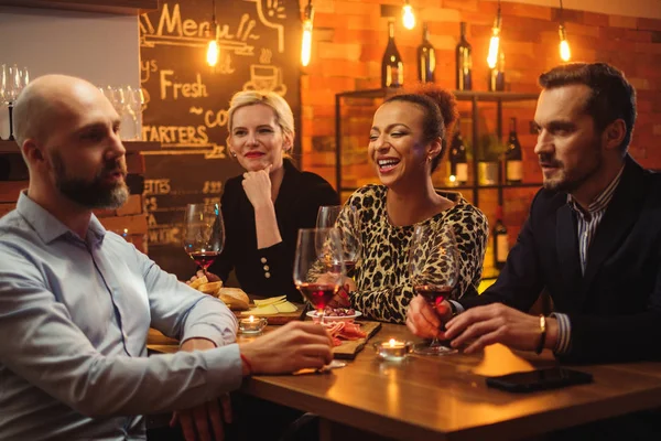 Grupo de amigos divirtiéndose hablando detrás del mostrador de la barra en un café — Foto de Stock