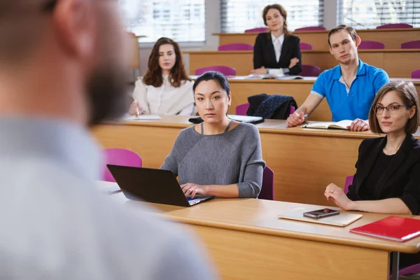 Chargé de cours et groupe multinational d'étudiants dans un auditorium — Photo