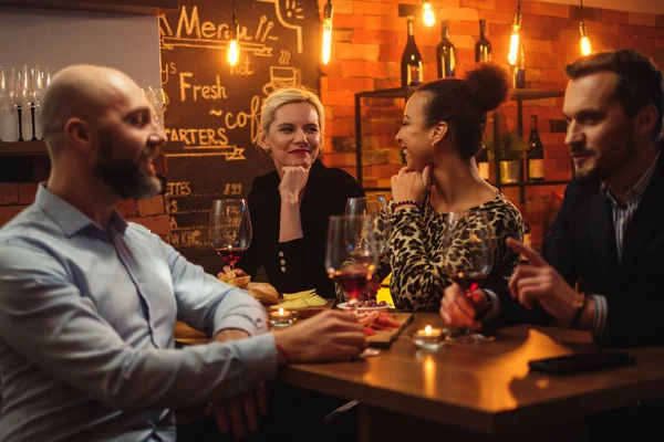 Grupo de amigos se divertindo conversando atrás do balcão de bar em um café — Fotografia de Stock