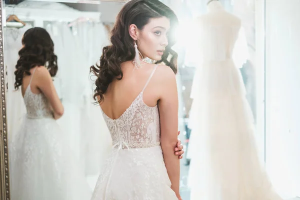 Beautifu novia elegir vestido de novia en un salón de bodas —  Fotos de Stock