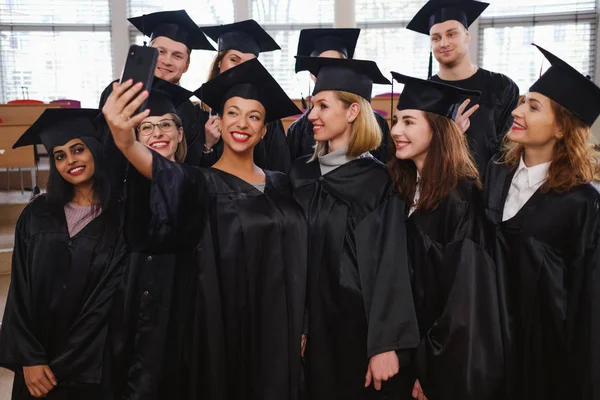 Groupe multi-ethnique d'étudiants diplômés prenant selfie — Photo