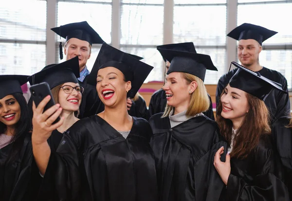 Groupe multi-ethnique d'étudiants diplômés prenant selfie — Photo