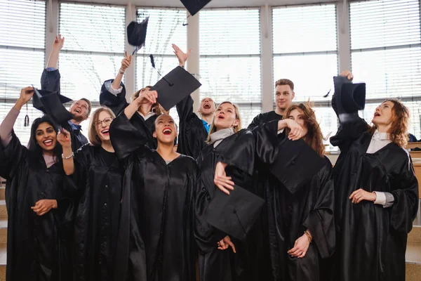 Multi etniska grupp graderad studenter kastar hattar — Stockfoto