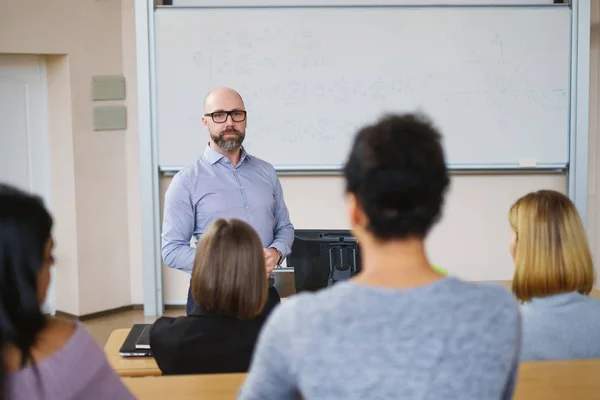 Chargé de cours et groupe multinational d'étudiants dans un auditorium — Photo