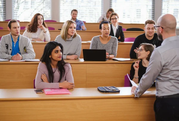 Docente e gruppo multinazionale di studenti in un auditorium — Foto Stock