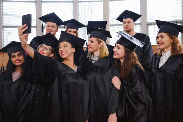 Grupo multiétnico de estudiantes graduados tomando selfie —  Fotos de Stock