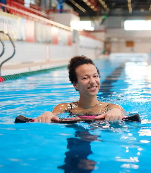 Mulher negra frequentando aula de aeróbica aquática em uma piscina — Fotografia de Stock