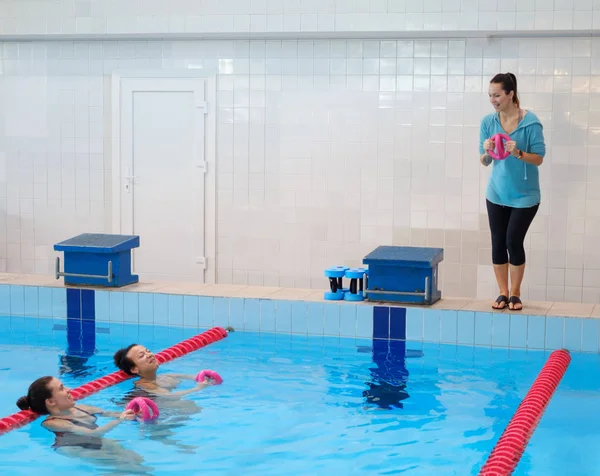 Pareja multiracial asistiendo a clases de aeróbic acuático en una piscina —  Fotos de Stock