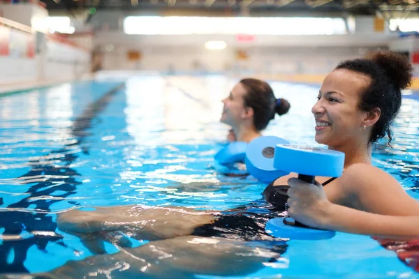 混血カップル スイミング プールで水中エアロビクスのクラスに参加 — ストック写真