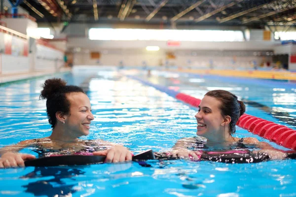 Casal multirracial frequentando aula de aeróbica aquática em piscina — Fotografia de Stock