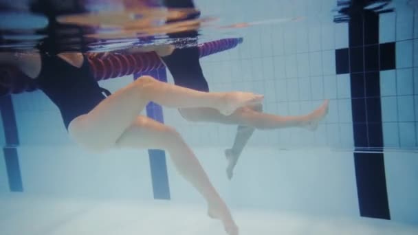 Çok ırklı çift su aerobiği sınıfı bir yüzme havuzunda katılıyor — Stok video