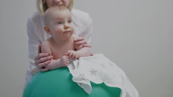 Baby jongen krijgt therapie op een fit bal — Stockvideo