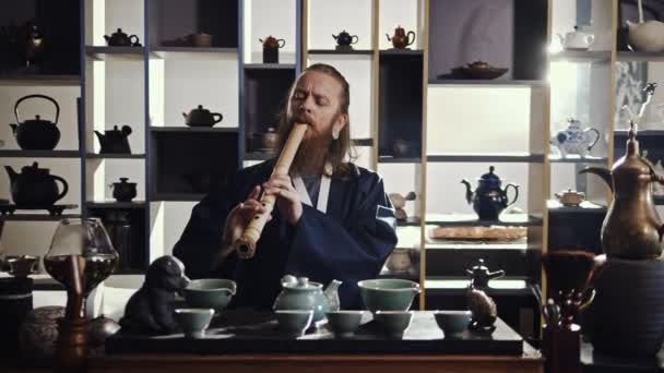 Мастер чая играет на флейте во время чайной церемонии — стоковое видео