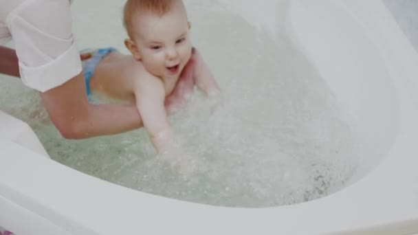 赤ん坊の男の子は水のマッサージを得る — ストック動画