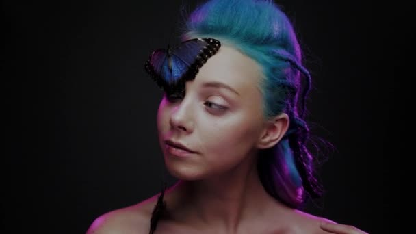 Όμορφη γυναίκα με μπλε μαλλιά και πεταλούδα — Αρχείο Βίντεο