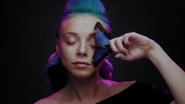 Piękna kobieta z niebieskimi włosami i motylem — Wideo stockowe