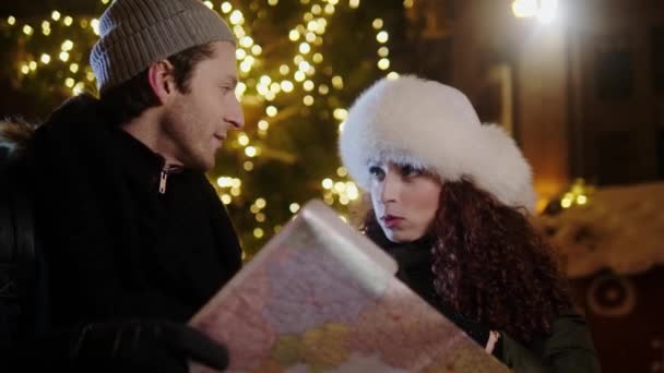 寒い冬の夜に地図を持つカップル — ストック動画