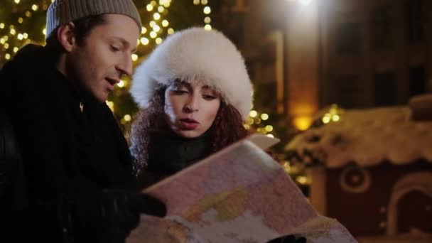 Pareja con un mapa en una fría noche de invierno — Vídeo de stock