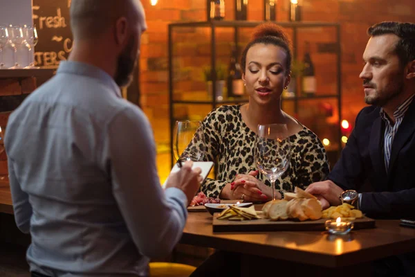 Casal conversando com barman atrás do balcão de bar em um café — Fotografia de Stock