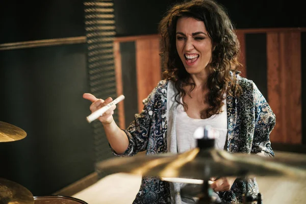 Woman playing drums during music band rehearsal — Stock Photo, Image