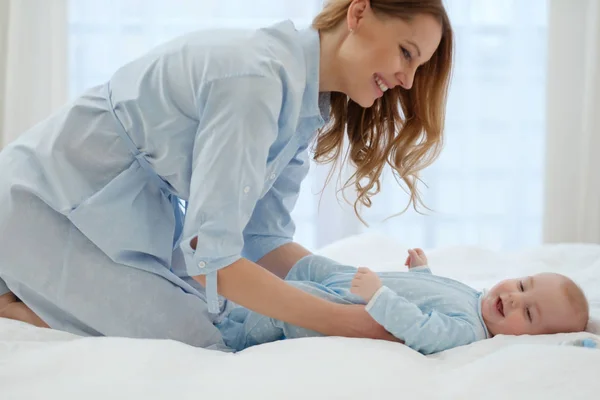 Mãe de meia-idade feliz com seu filho em uma cama — Fotografia de Stock