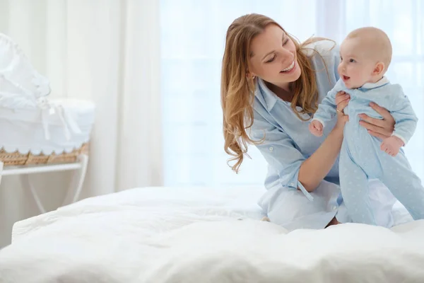Szczęśliwy średniej wieku matki z dzieckiem w łóżku — Zdjęcie stockowe