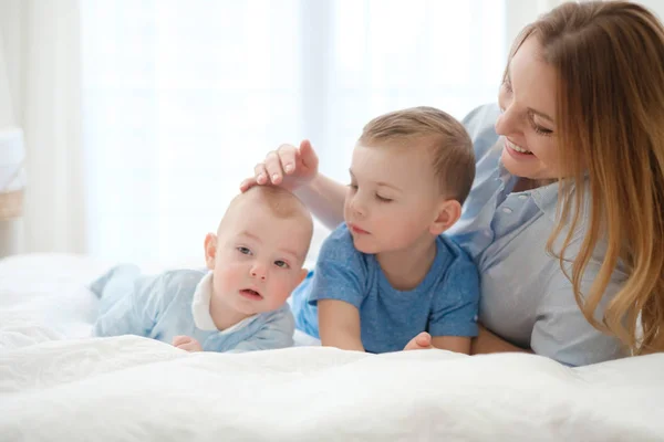 침대에서 그녀의 아이 들과 함께 행복 한 중간 세 어머니 — 스톡 사진