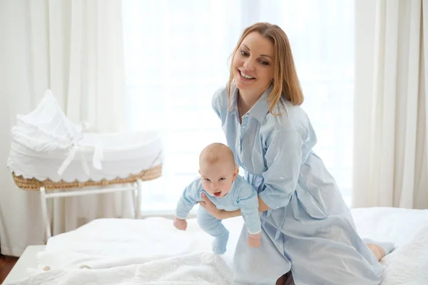 Feliz madre de mediana edad con su hijo en una cama —  Fotos de Stock