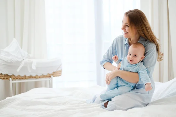 Glad mitten gamla mor med sitt barn i en säng — Stockfoto