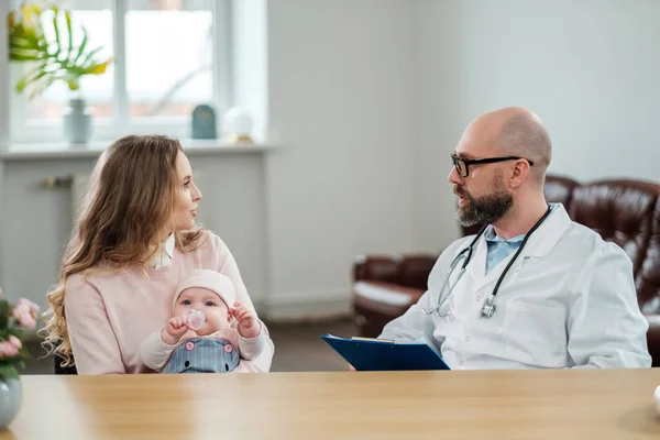 Mãe com bebê pediatra visitante — Fotografia de Stock