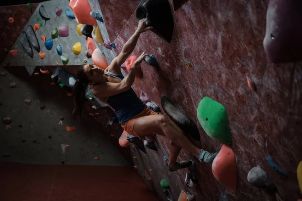 Mujer atlética practicando en un gimnasio de bouldering — Foto de Stock