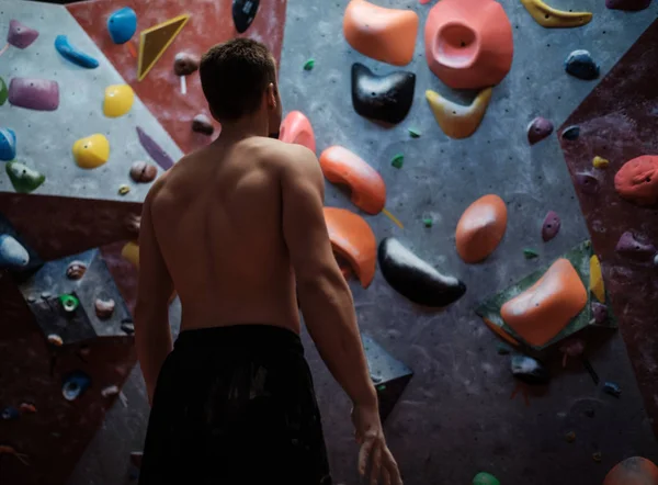 Atletisk man stretching innan klättring i bouldering gym — Stockfoto
