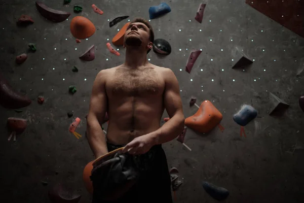 Uomo atletico che usa il gesso prima di arrampicarsi in una palestra di boulder — Foto Stock