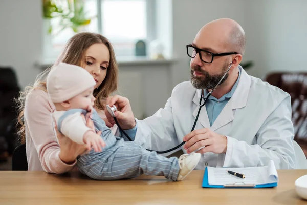 Mother with baby visiting pediatrician — Stock Photo, Image