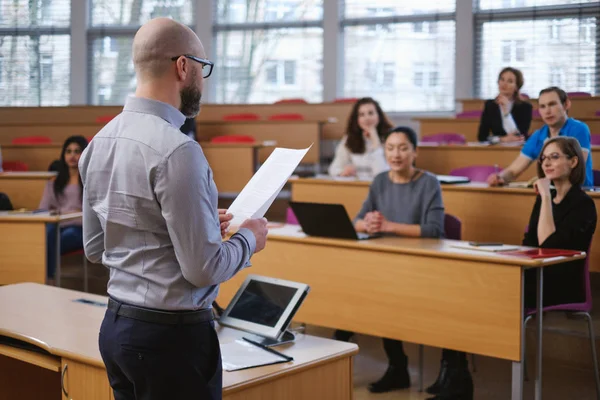 Profesor y grupo multinacional de estudiantes en un auditorio —  Fotos de Stock