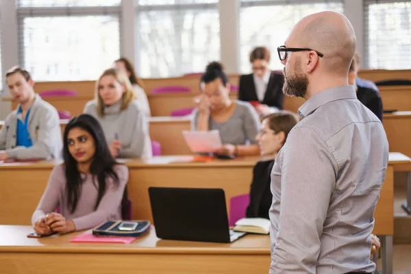 Docent en multinationale groep studenten in een auditorium — Stockfoto