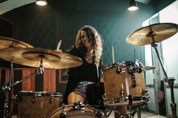 Жінка грає на барабанах під час репетиції музичного гурту — стокове фото