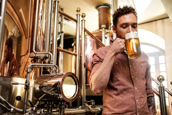 Man die vers bier in een brouwerij proeft — Stockfoto