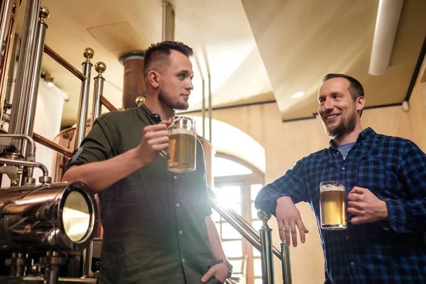 Dos hombres degustando cerveza fresca en una cervecería —  Fotos de Stock