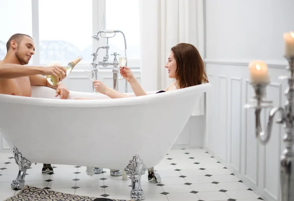 Paar leggen in een bad met glas Champagne — Stockfoto