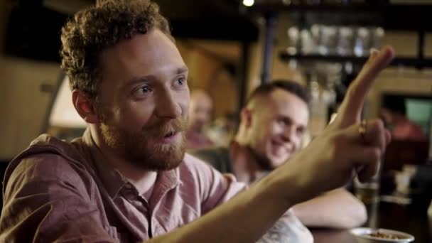 Vrolijke vrienden die bier van de tap drinken in een pub — Stockvideo