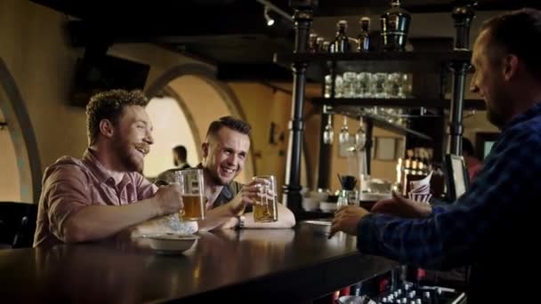 Fröhliche Freunde, die Bier vom Fass in einer Kneipe trinken — Stockvideo