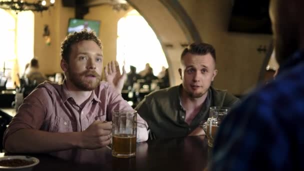 Amigos alegres bebendo cerveja rascunho em um bar — Vídeo de Stock