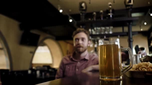 Vrienden drinken bier van de tap en tv kijken in een pub — Stockvideo
