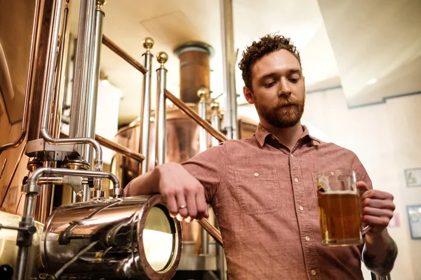 Člověk ochutná čerstvé pivo v pivovaru — Stock fotografie