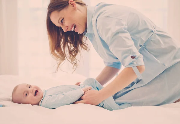 Mãe de meia-idade feliz com seu filho em uma cama — Fotografia de Stock