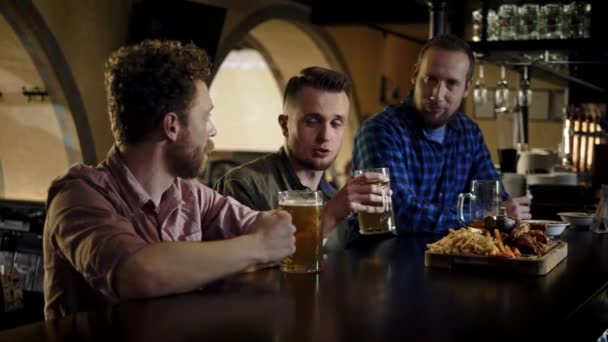 Vrolijke vrienden die bier van de tap drinken in een pub — Stockvideo