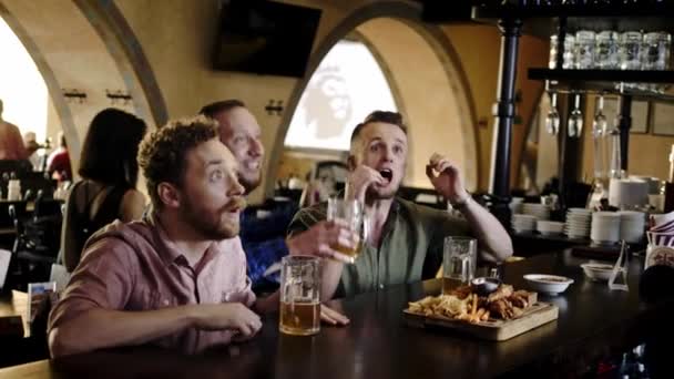 Amigos alegres bebiendo cerveza de barril en un pub — Vídeo de stock