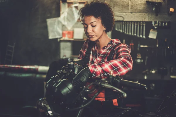 Meccanico afroamericano che ripara una moto in officina — Foto Stock